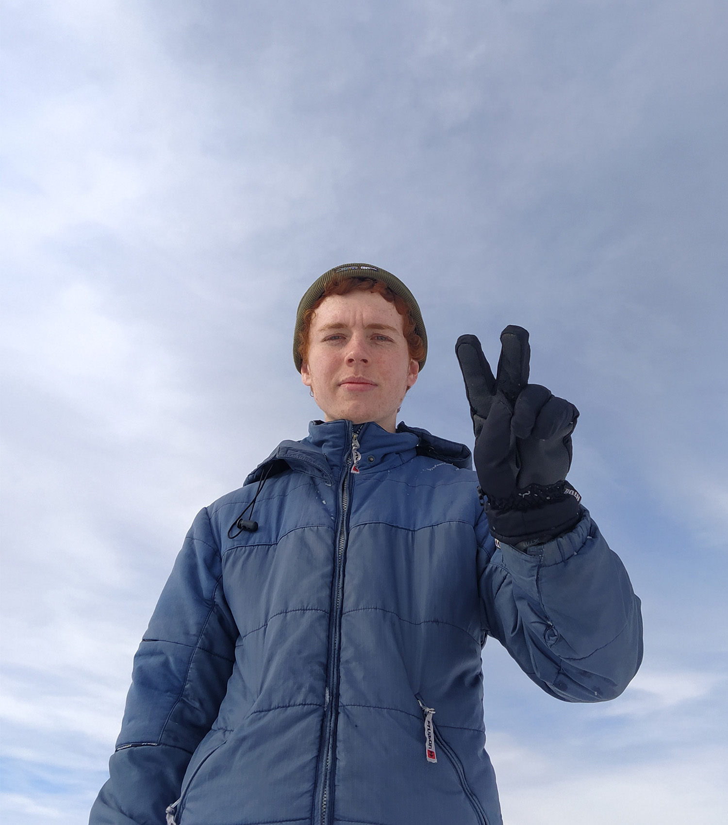 photograph of me in winter-wear holding up the peace sign